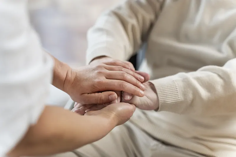 A healthcare professional offering reassurance to an older patient